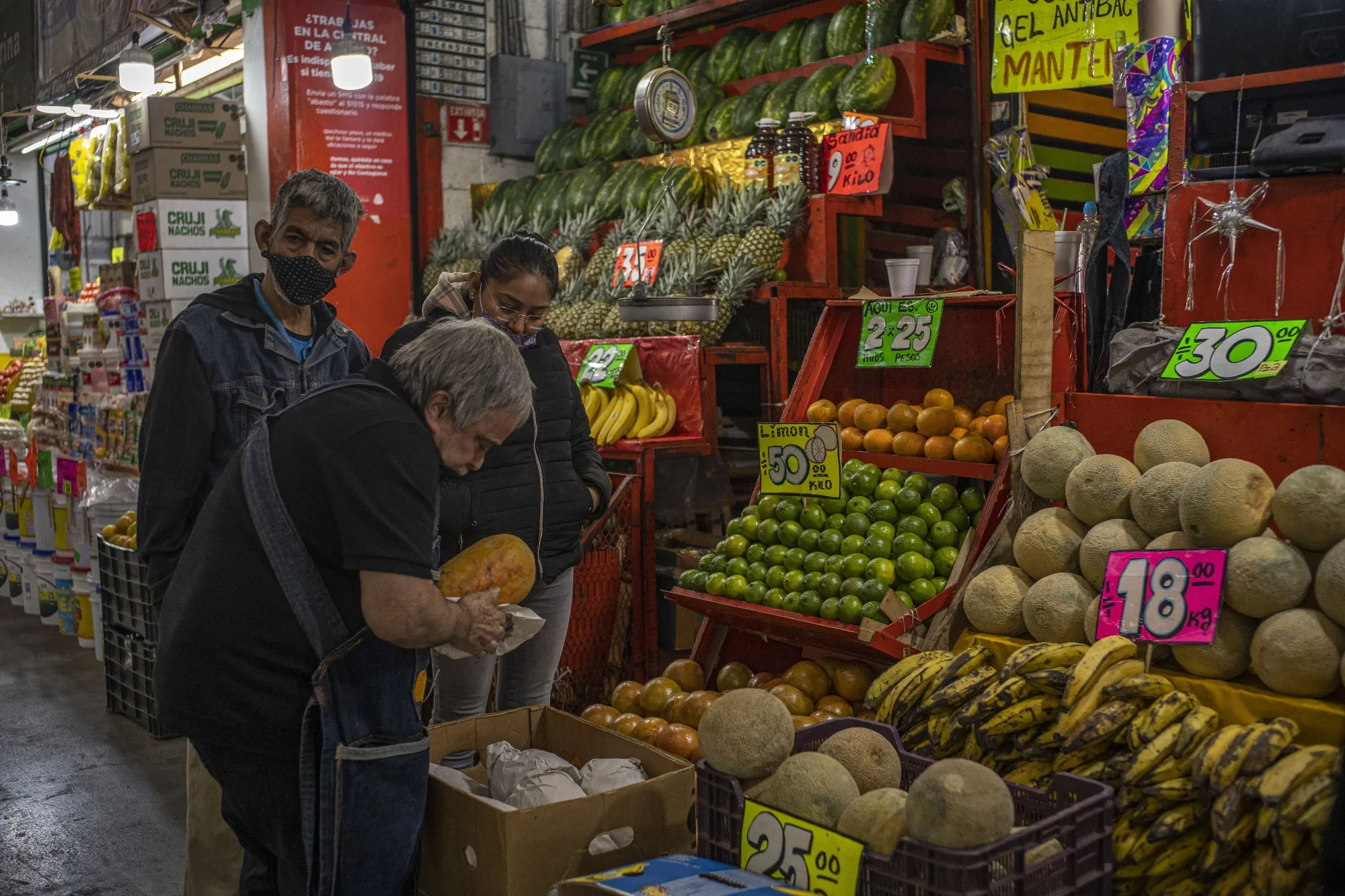 A vendor holds a papaya at the Central de Abastos market in Mexico City.
