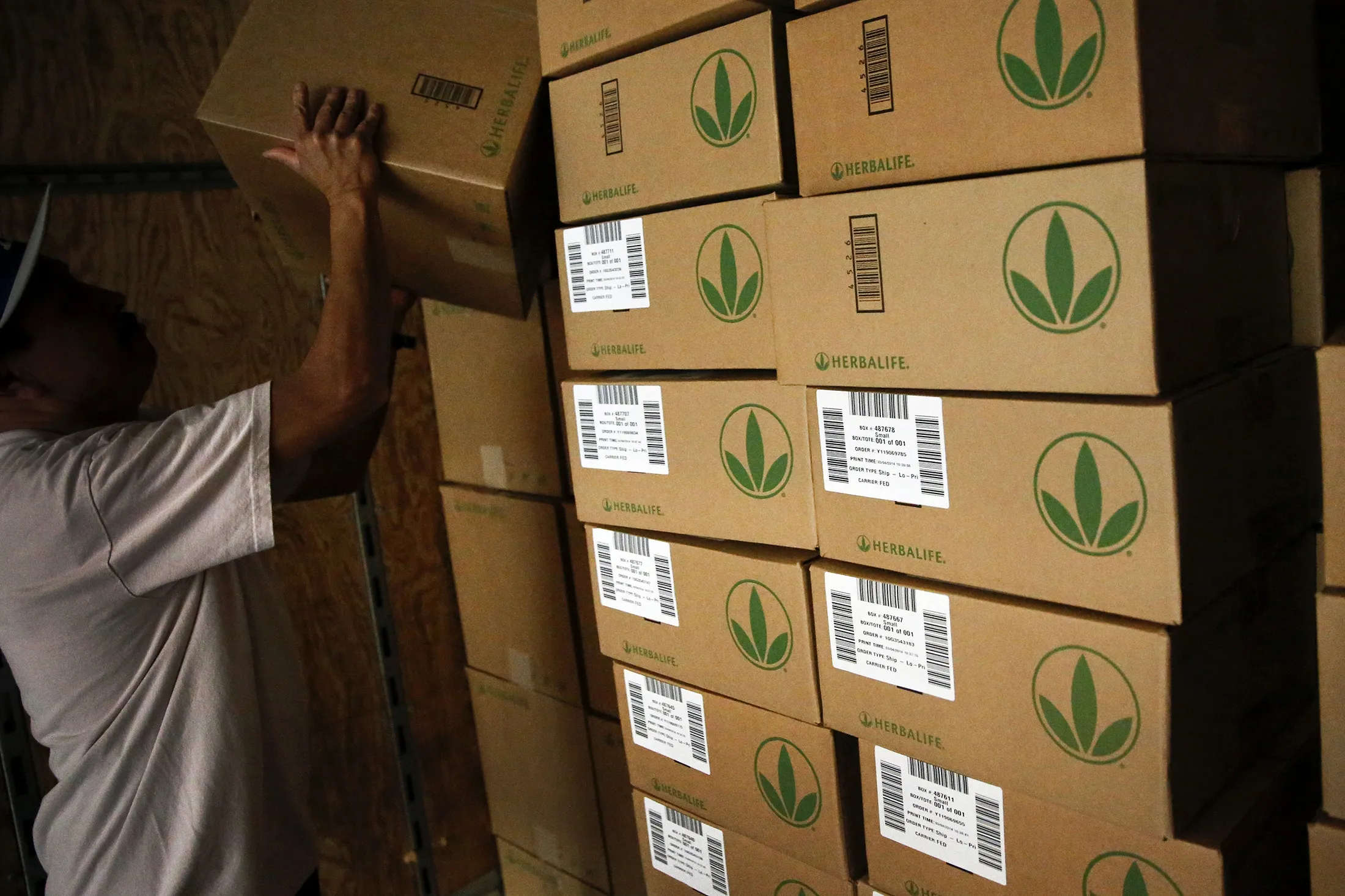 A worker stacks boxes of Herbalife shipments in a truck at the Los Angeles Distribution Center in Carson, California.

