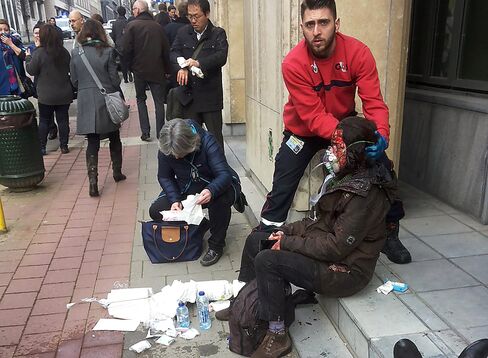 A private security guard helps a wounded woman at the Maalbeek metro on March 22.