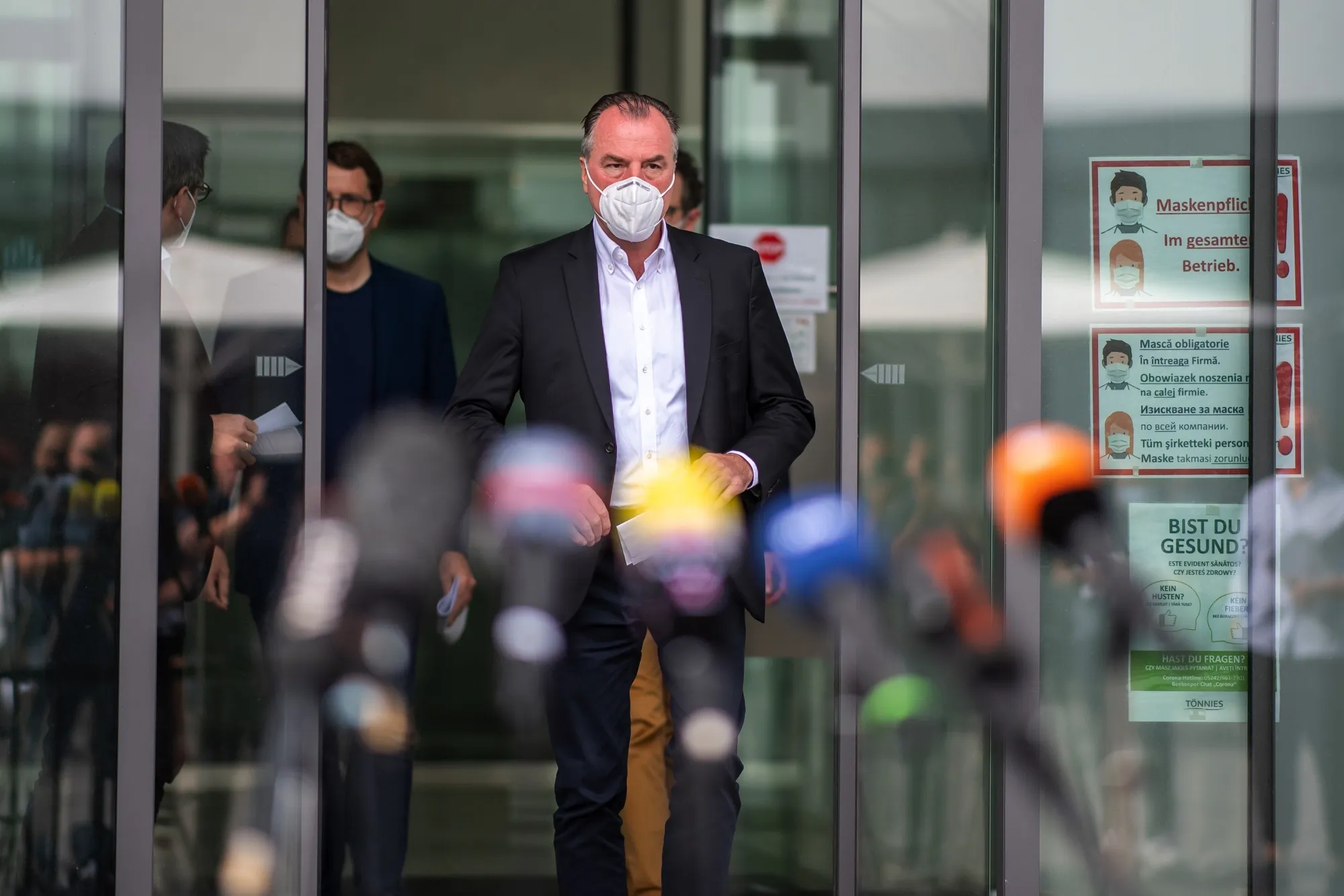 Clemens Toennies heads to speak with the press outside the slaugherhouse, on June 20.