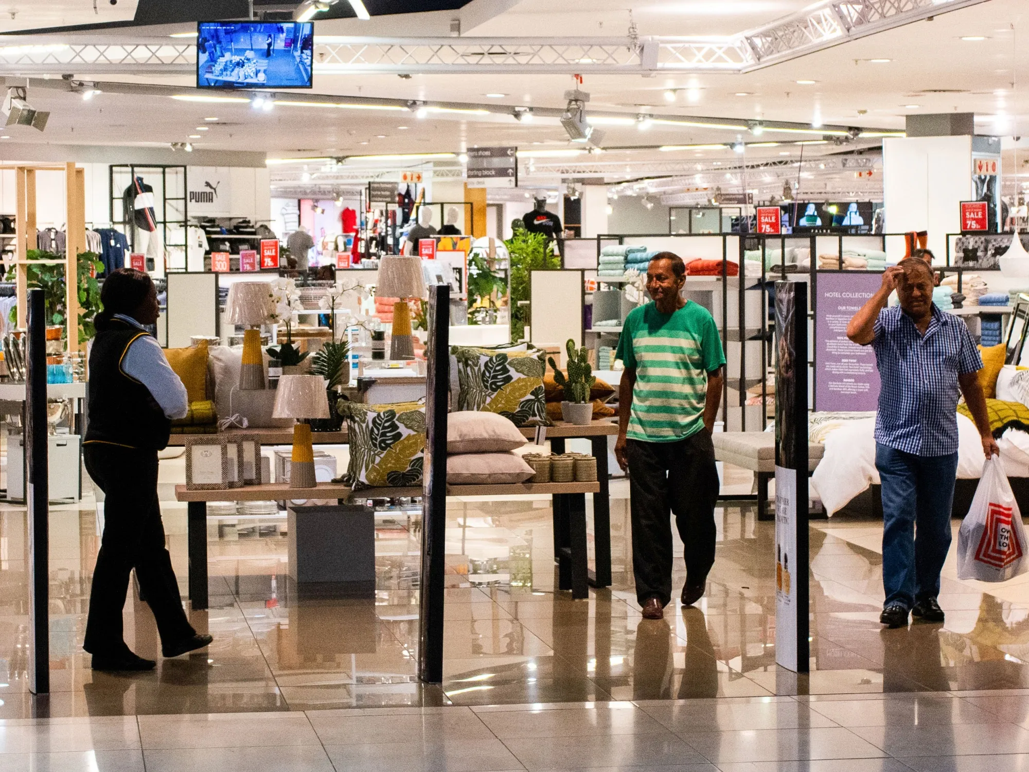 Shoppers exit an Edgars fashion and homeware store, operated by Edcon Holdings Ltd., in Johannesburg, South Africa, on Monday, Feb. 4, 2019. Edcon Holdings is making progress toward securing 3 billion rand ($226 million) in funding to keep the South African clothing retailer afloat, with the Public Investment Corp. part of the ongoing talks.