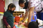 Teacher Shanikia Johnson helps 3-year-old Magjor Jones clean up a puzzle at Little Flowers Early Childhood and Development Center in the Sandtown-Winchester neighborhood of Baltimore, Maryland, in 2021.