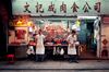 Two butchers selling fresh outside their street market stall at night