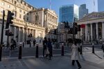 Commuters pass the Bank of England in London. Photographer: Jason Alden/Bloomberg