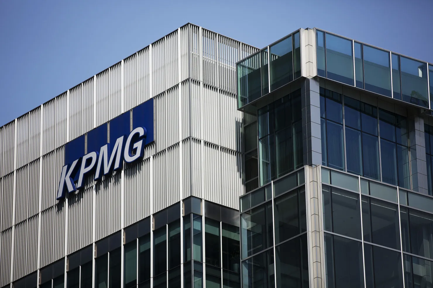 A logo sits on display outside the offices of KPMG LLP in the Canary Wharf business and shopping district in London, U.K.