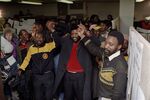 James Motlatse, center, president of the National Union of Mineworkers (NUM) and Cyril Ramaphosa, right, general secretary of NUM join hands in singing the national anthem with mineworkers after the NUM executive had met in Aug. 1987.