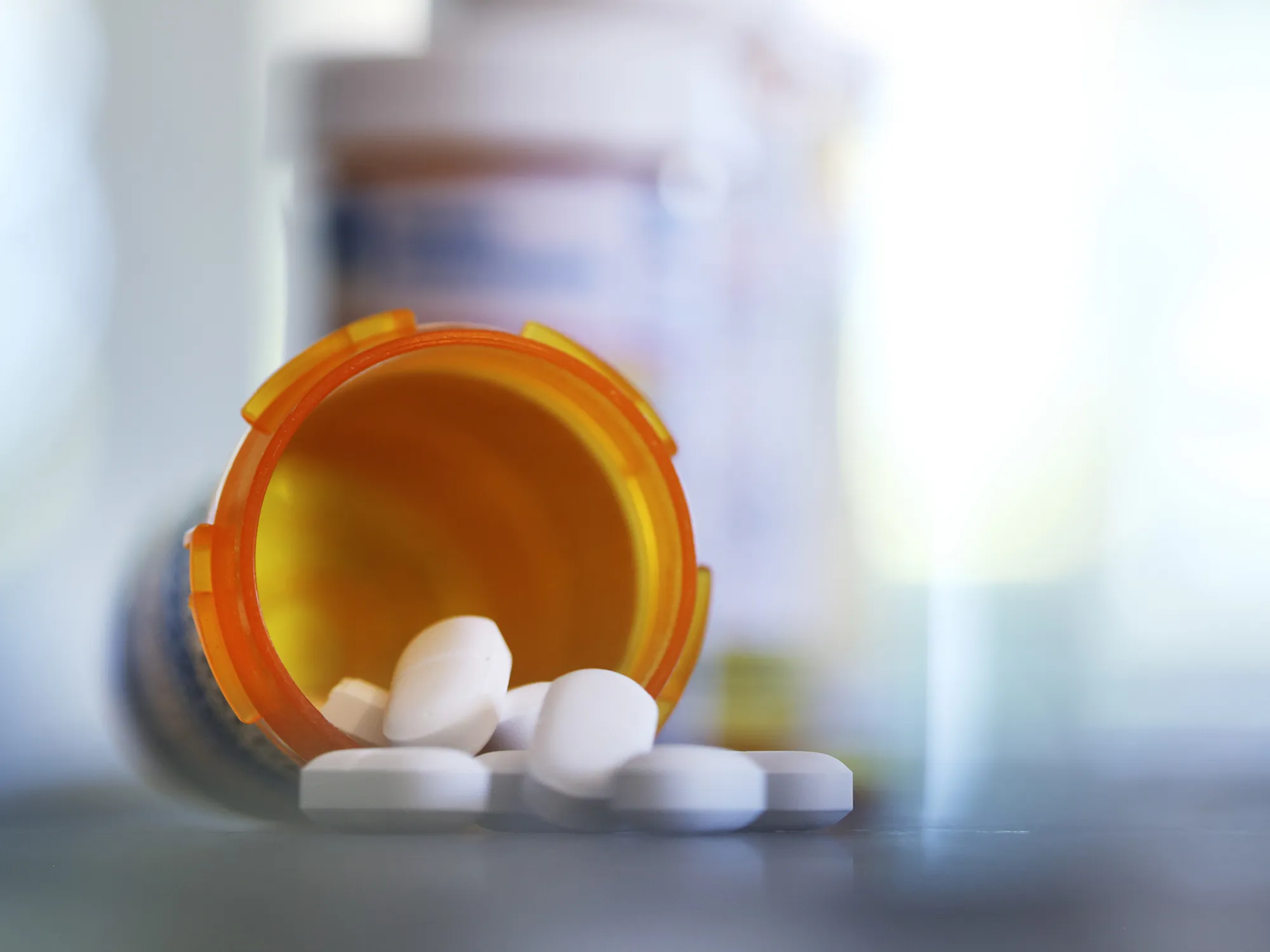 Pills pour out of a prescription medication bottle