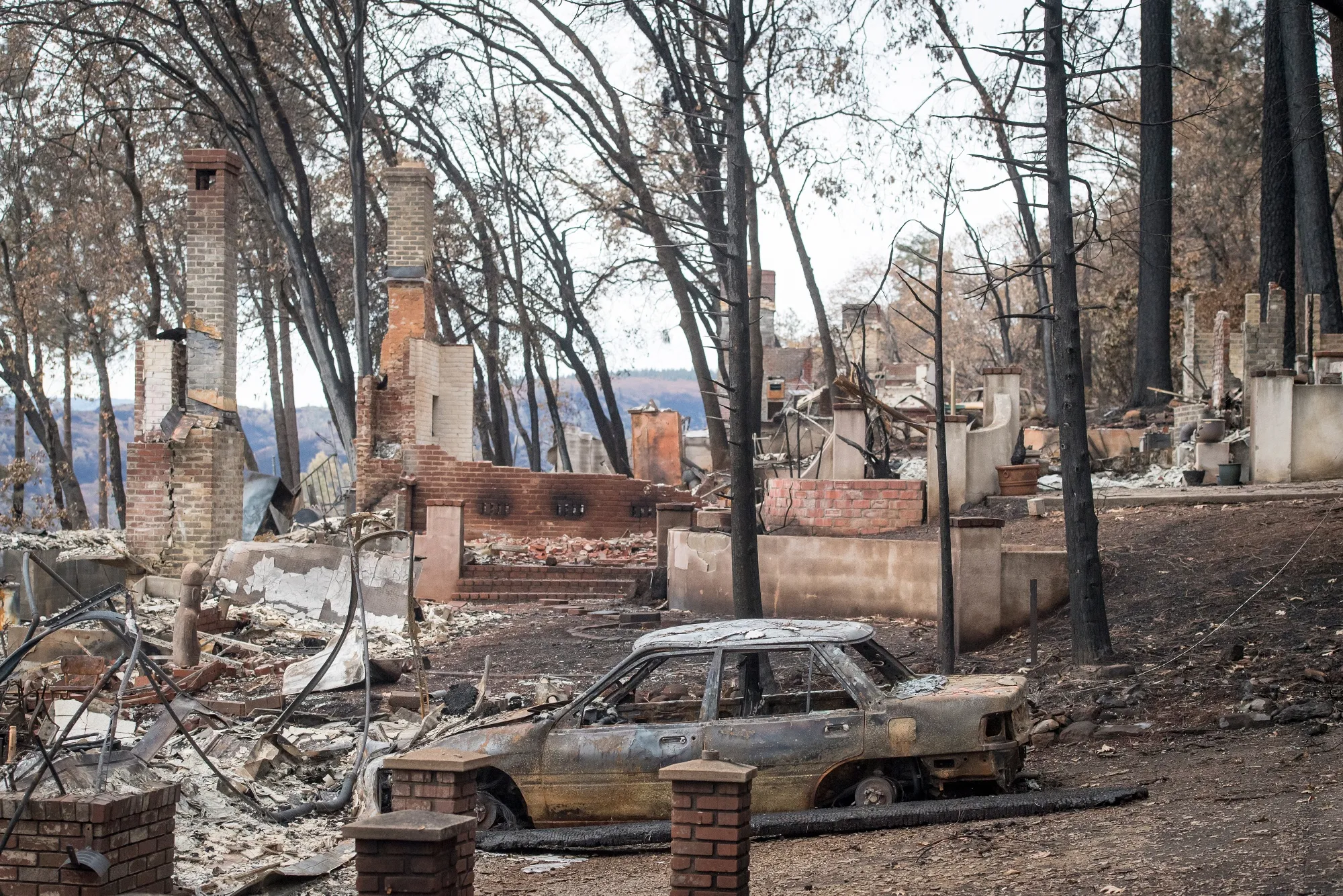 A burned-out vehicle is seen near destroyed homes in Paradise, California on Nov. 26, 2018.