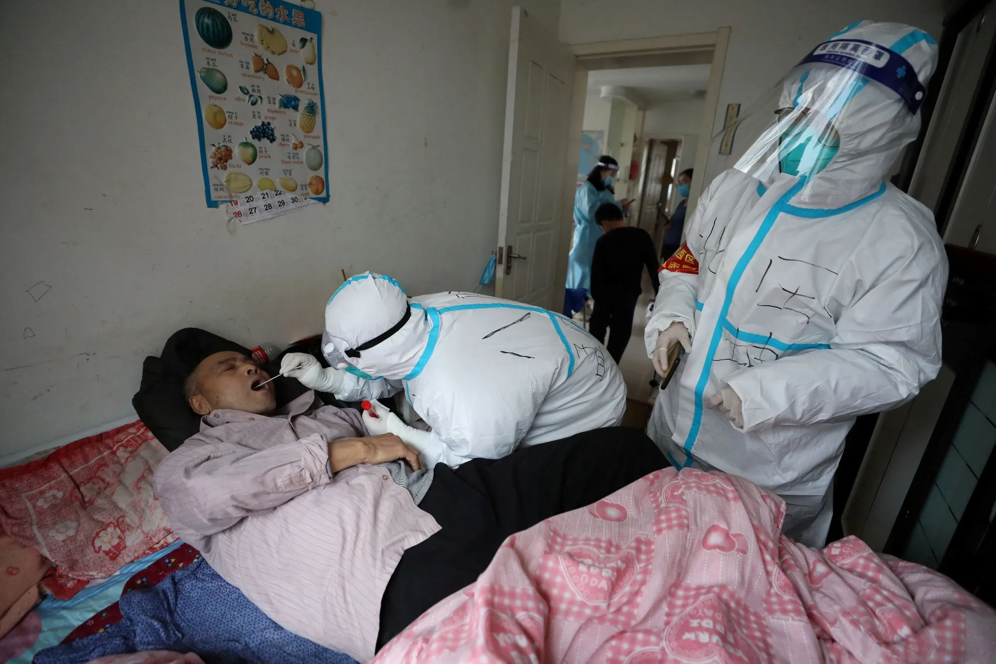 A medical worker takes a swab sample during a home visit in Shenyang, China, on March 23.
