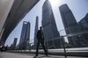 A pedestrian wearing a protective mask walks through the Lujiazui Financial District in Shanghai, China, on Friday, March 20, 2020. Most of China is now considered low risk and should return to normal work and life, Premier Li Keqiang said at a government meeting on the coronavirus, which is spreading rapidly in Europe, the U.S. and elsewhere.