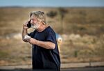 Alec Baldwin speaks on the phone in the parking lot outside the Santa Fe County Sheriff's Office in Santa Fe, N.M., after he was questioned about a shooting on the set of the film "Rust" on Thursday, Oct. 21, 2021.