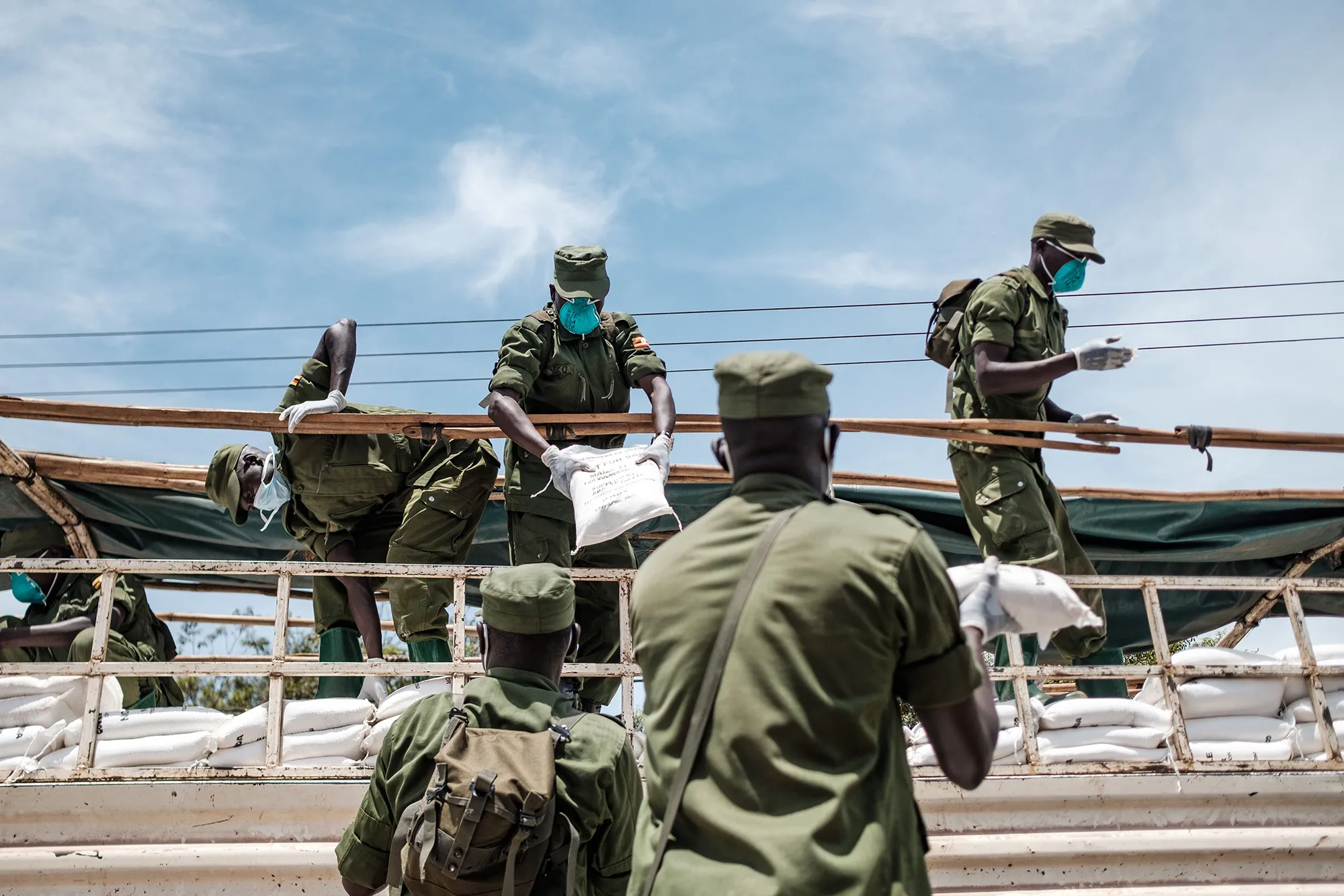 A paramilitary force composed of civilians unloads flour&nbsp;during the first day of the government's food distribution for people who have been affected by the lockdown in Kampala, on April 4.