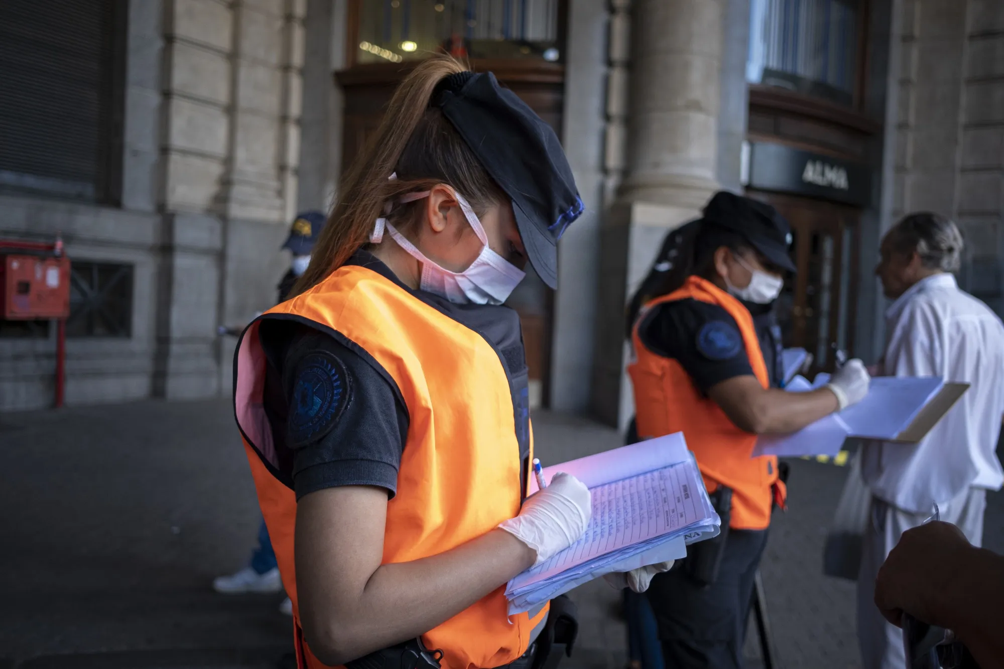 Police officers take notes while inspecting commuters' credentials at the Retiro railway station in Buenos Aires, Argentina, on&nbsp;March 27.&nbsp;