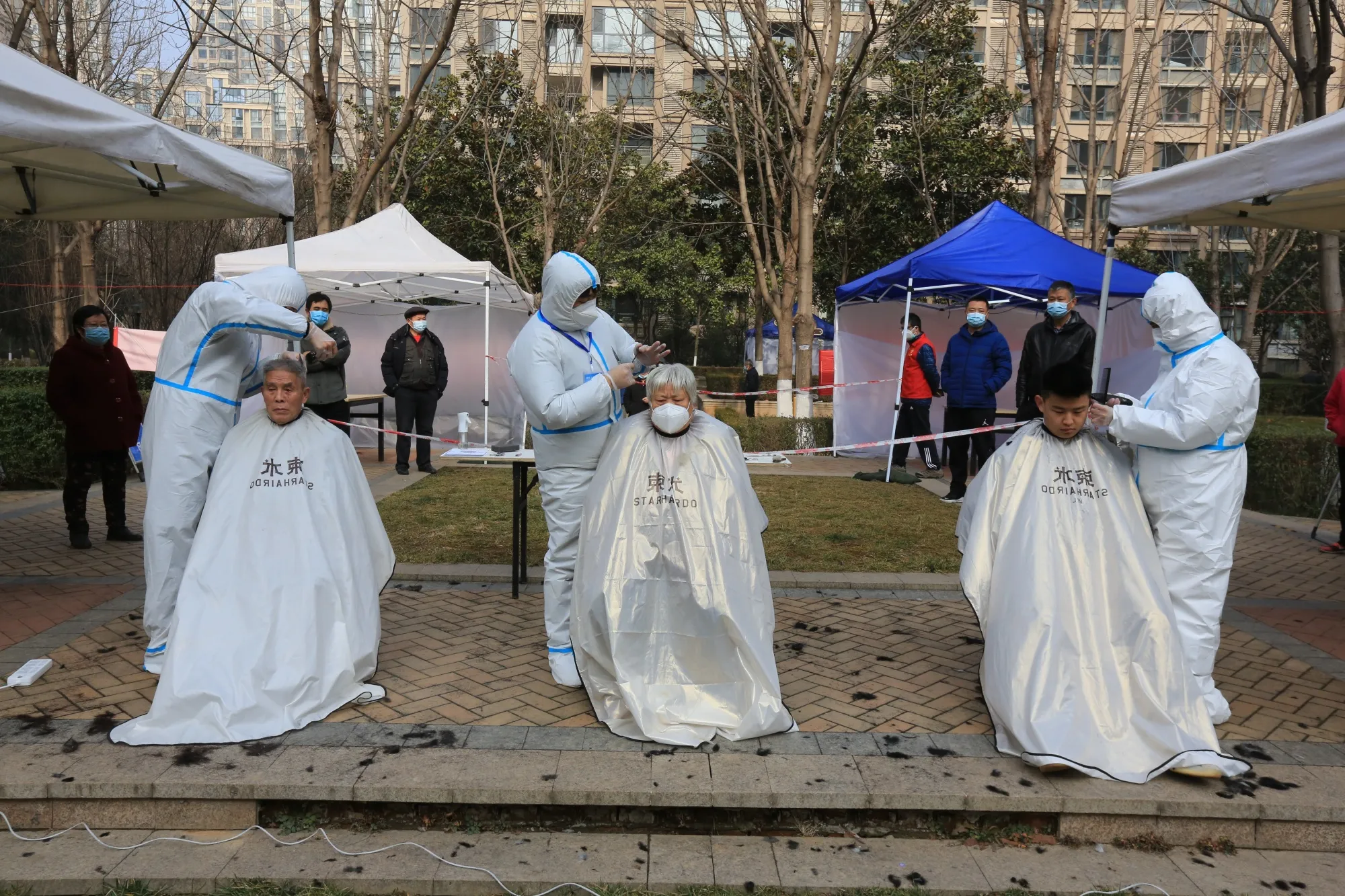 Open-air haircuts in Xian, China, under lockdown.