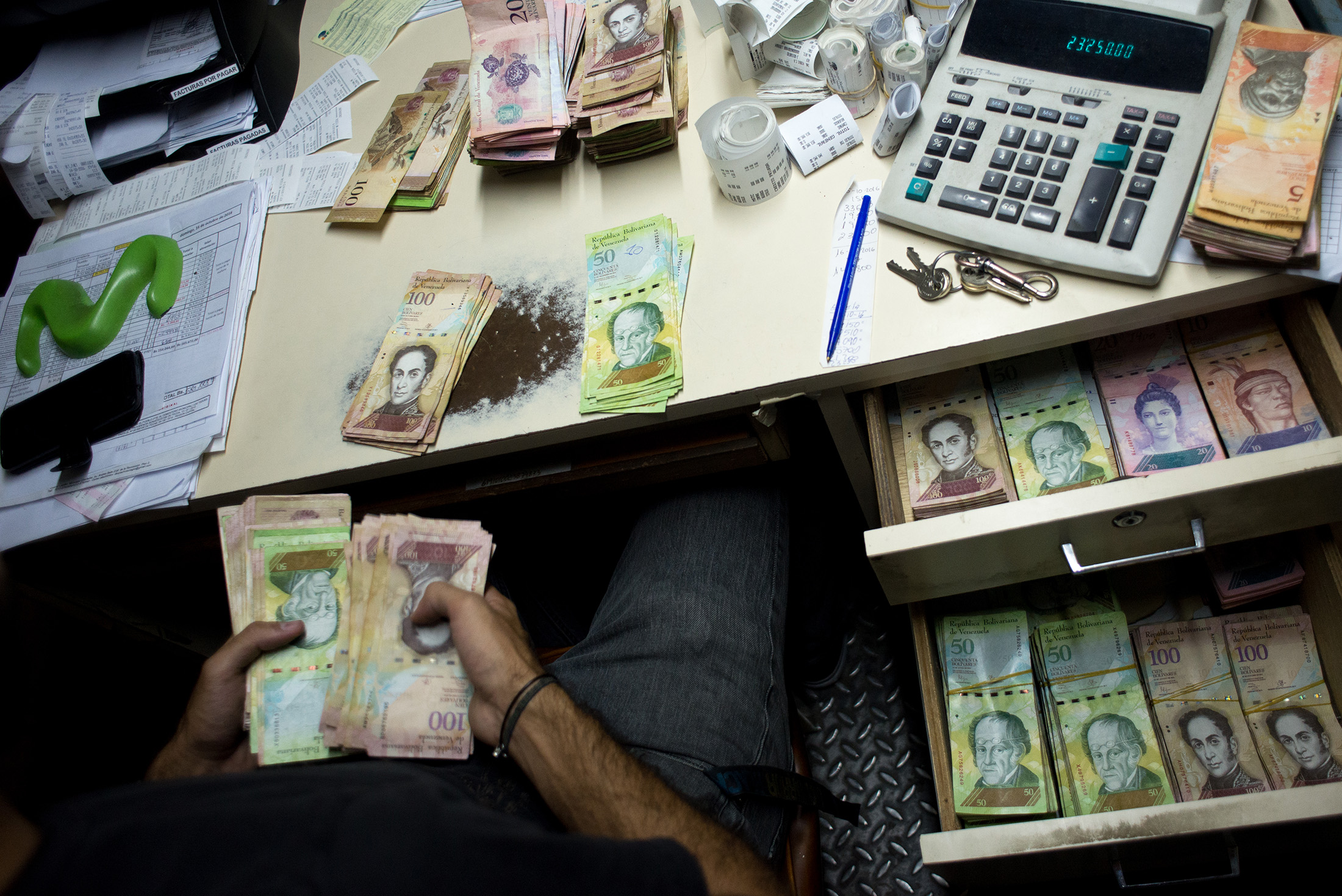 A manager counts the incoming cash of the day at a bakery in Caracas, Venezuela, on Oct. 16, 2016.

