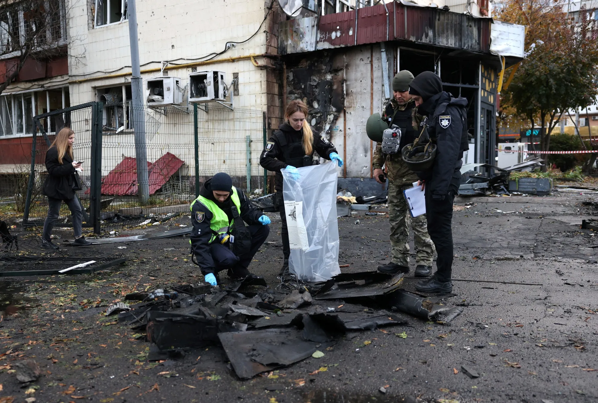 Police officers collect evidence&nbsp;at the site of a Russian drone strike in Kyiv, on Oct. 29.