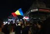 A supporter waves a Romanian flag outside the campaign headquarters of Nicusor Dan.