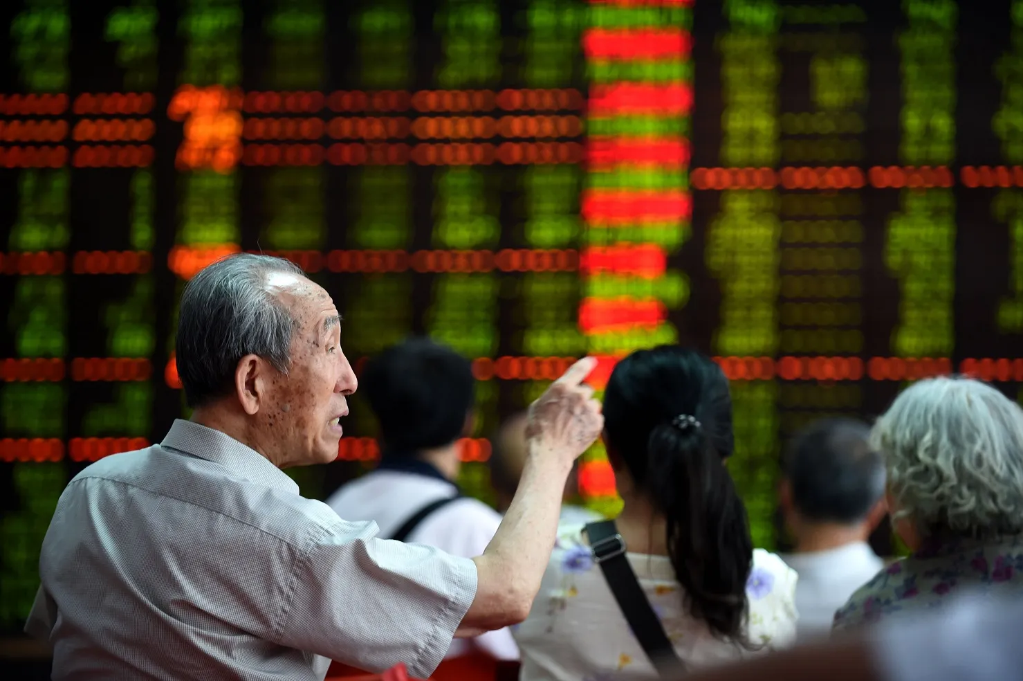 Investors look through stock information at a trading hall in a securities firm in Shenyang, northeast China's Liaoning Province.
