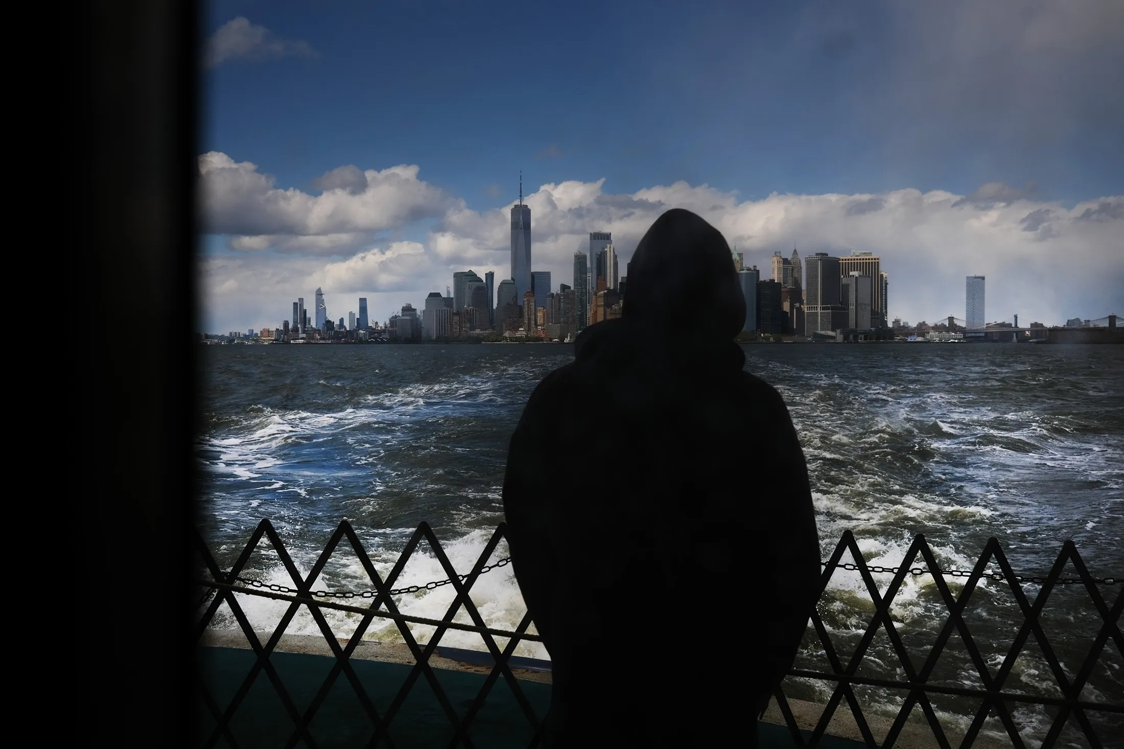 The Manhattan skyline stands in the distance as people ride the Staten Island Ferry on May 09.