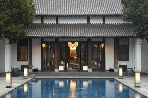 Outside the sitting room, divided by antique Chinese screens, is a softly lit swimming pool.