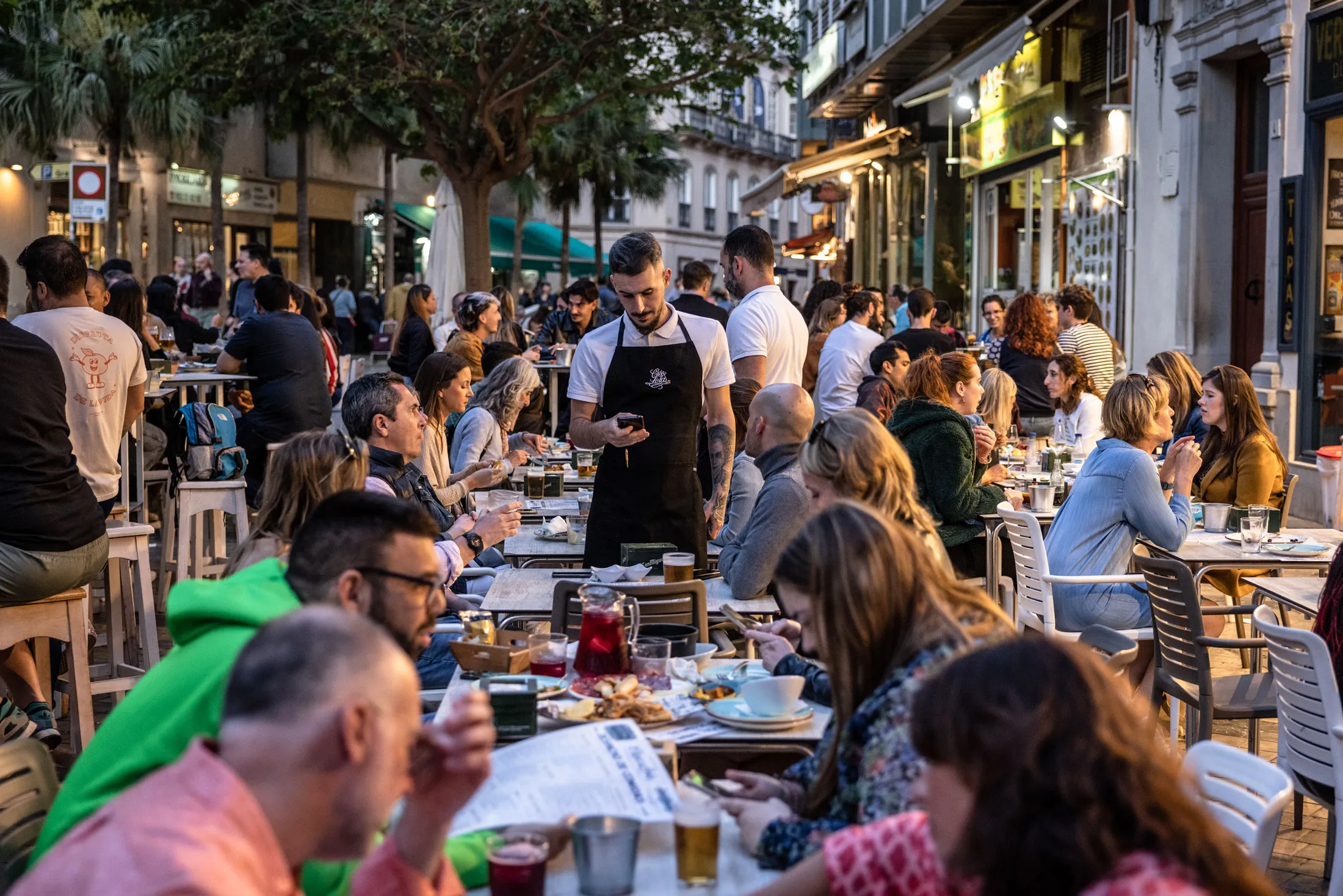 Diners on a restaurant terrace in Malaga, Spain.