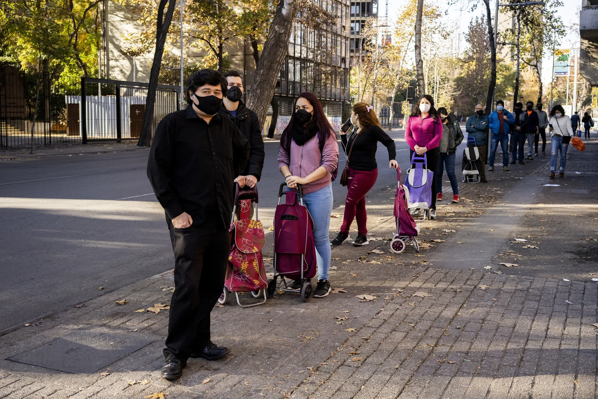 People wearing protective masks stand in line to enter a store in the city center of Santiago, Chile, on&nbsp;June 13.