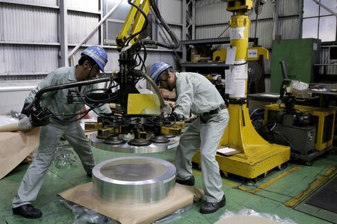 Employees operate machinery to stack coils of slit aluminum strips