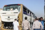 People stand next a damaged tour bus after an explosion in Giza on May 19.