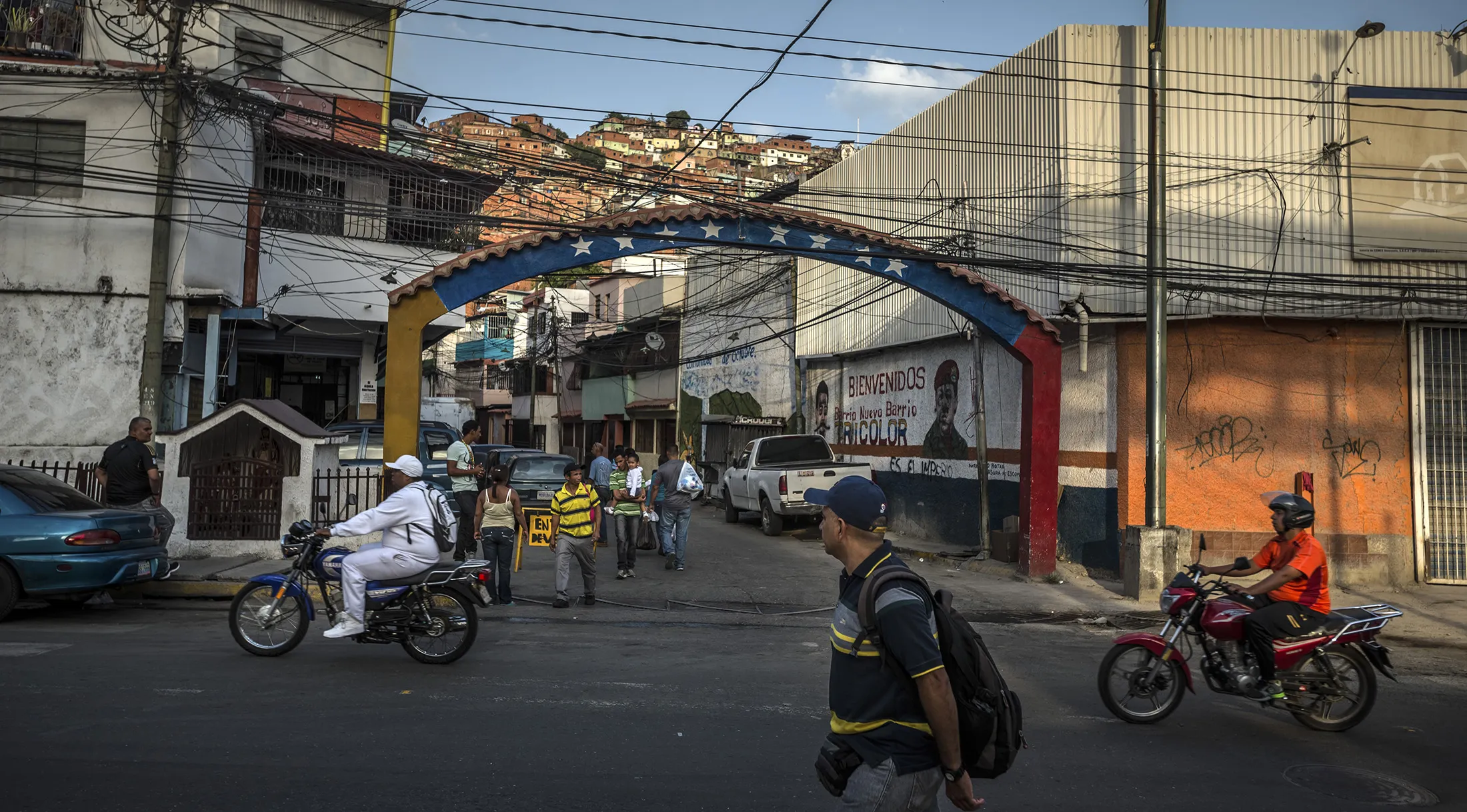People drive motorcycles along the street in the Petare neighborhood on the outskirts of Caracas.
