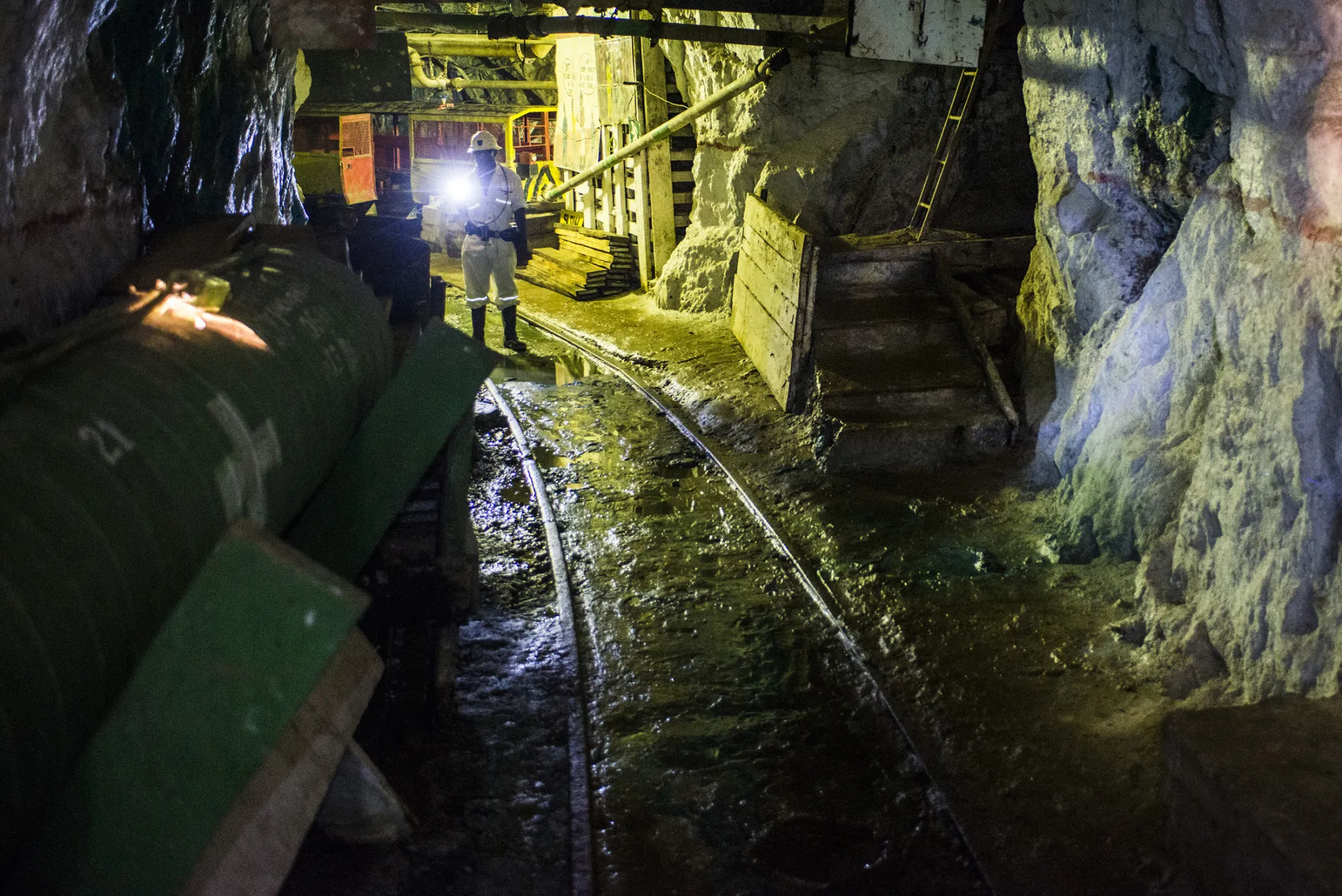 A miner stands on a rail track in an underground tunnel at a copper mine in Chingola, Zambia.
