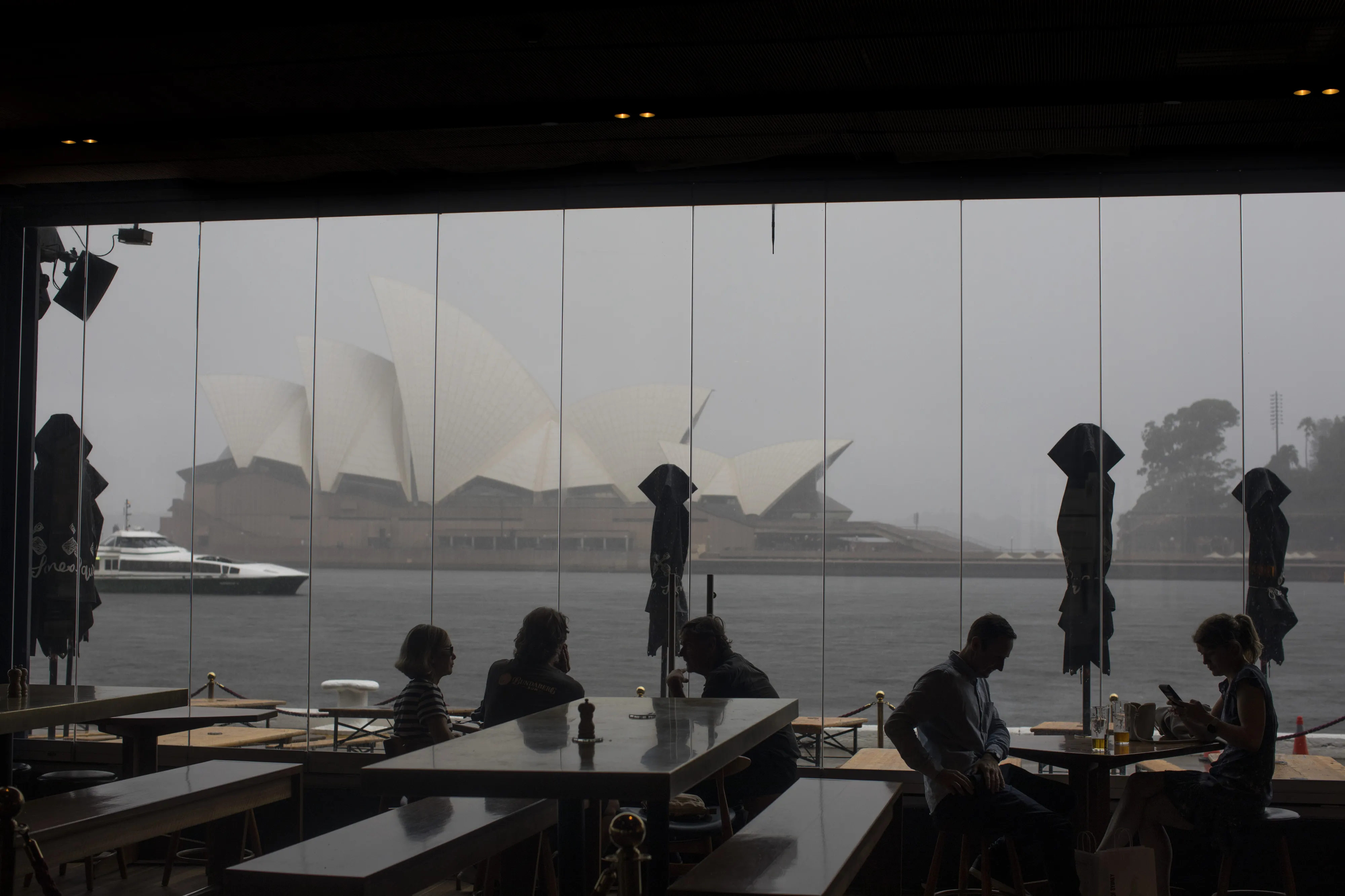 Customers sit at a cafe near Sydney Opera House in Sydney, Australia.