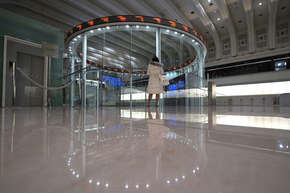 A visitor looks at an electronic ticker at the Tokyo Stock Exchange (TSE).