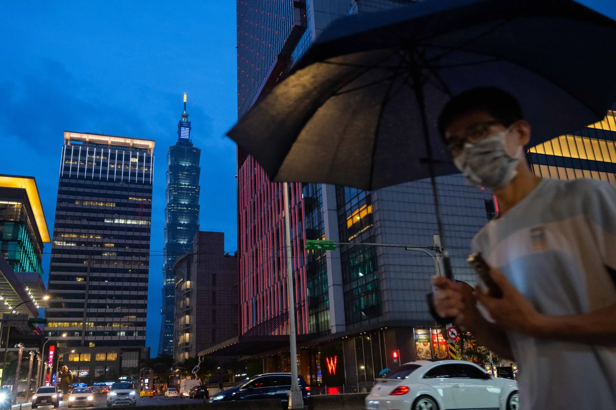 A pedestrian passes in front of Taipei 101 tower in Taipei, Taiwan.