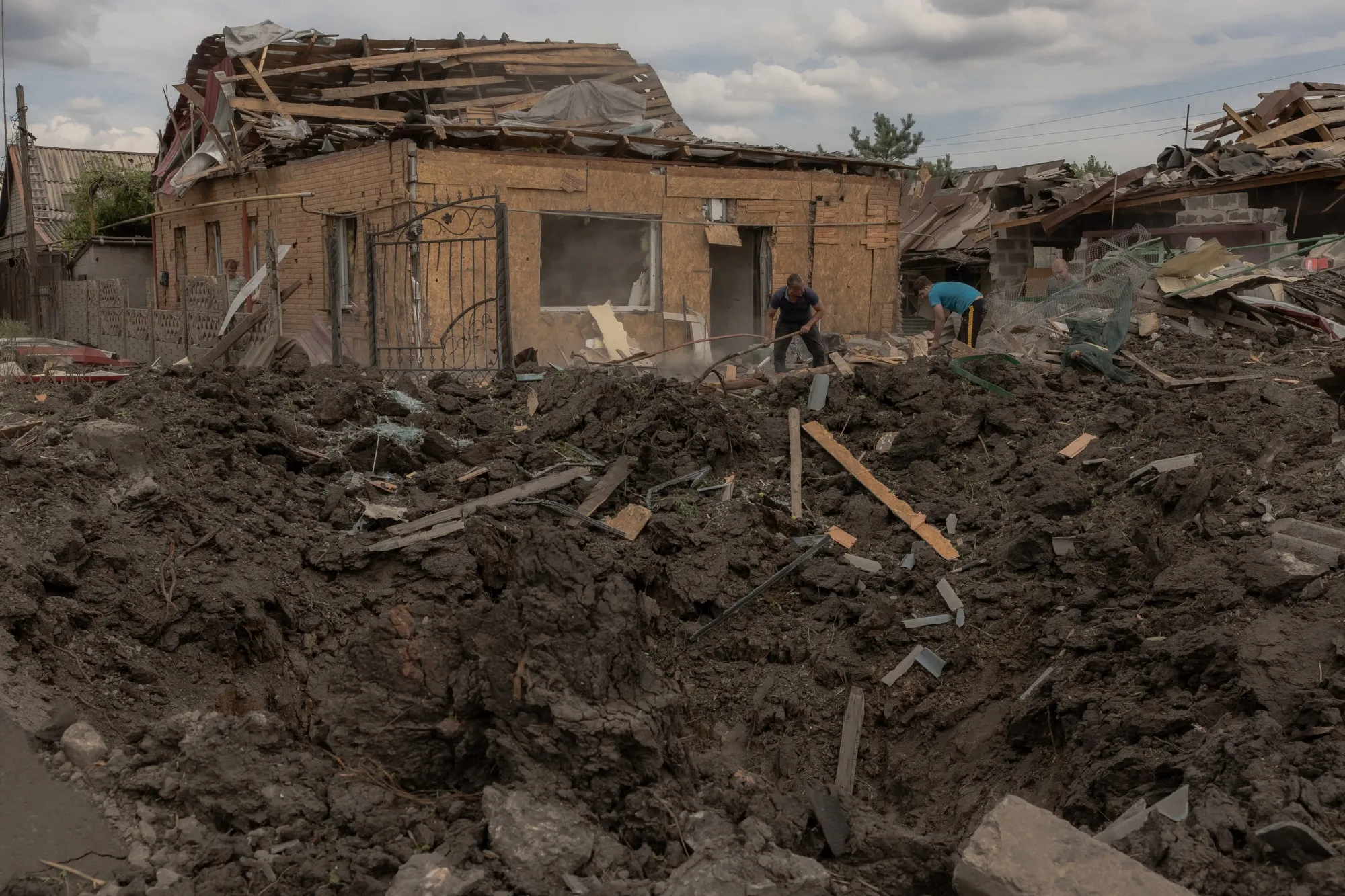 Residents clean debris next to heavily damaged houses following shelling in Pokrovsk ,Ukraine, on June 24.