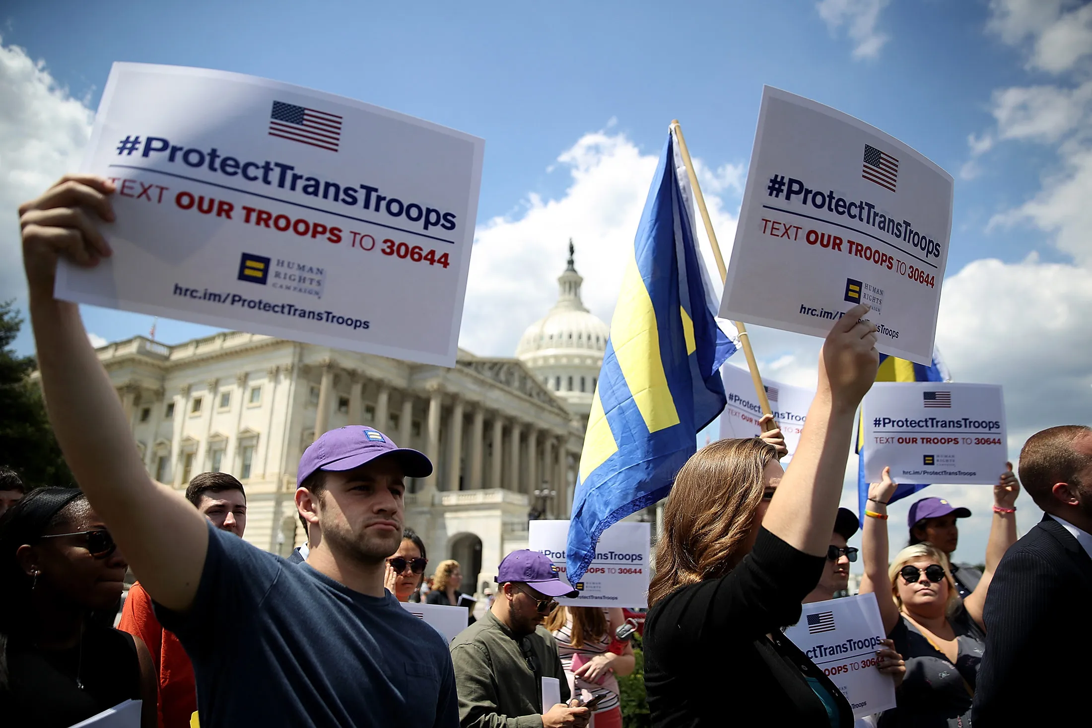 Protesters hold signs condemning the ban on transgender service members in Washington, D.C., on July 26, 2017.

