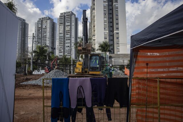 Wetsuits hang on a fence to dry near construction at Beyond The Club. 