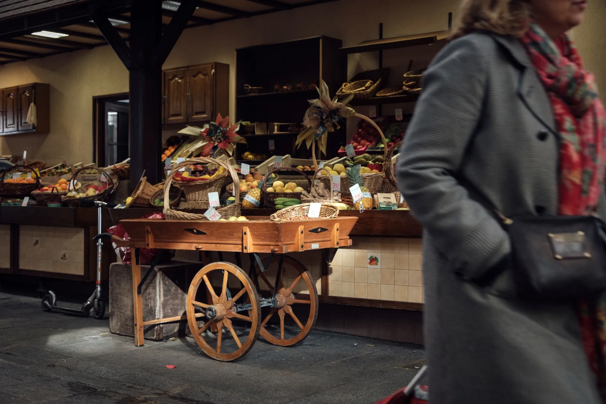 A shopper passes a fruit and vegetable stall in the Bauveau Market in Paris.