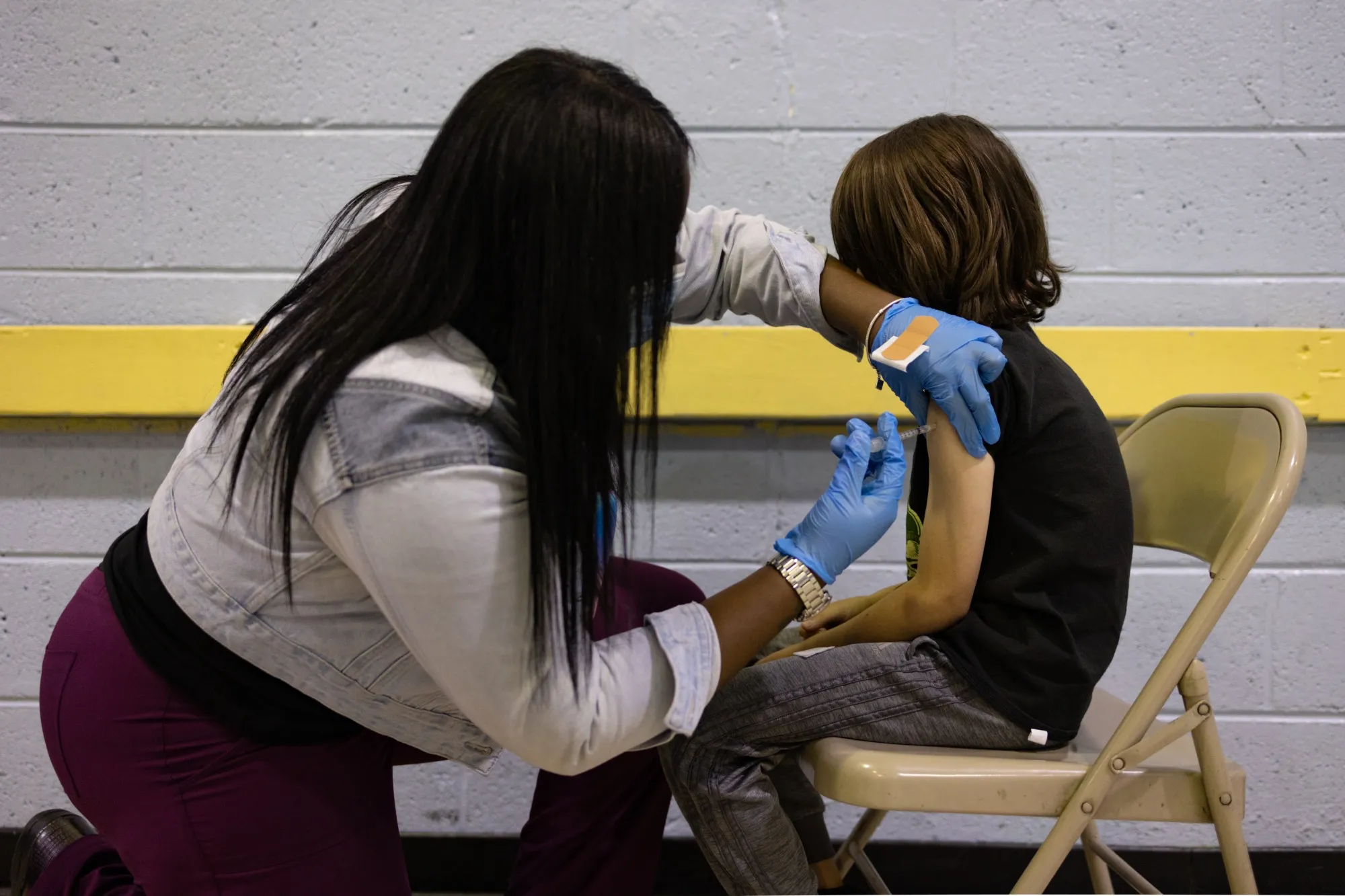 A healthcare worker administers a vaccine to a child at a vaccination clinic in Philadelphia.