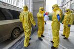 Members of a funeral parlour wearing protective suits disinfecting a colleague after they transferred a body at a hospital in Wuhan in China's central Hubei province, during the virus outbreak in the city on Jan. 30.