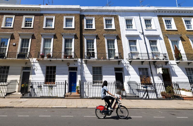 A cyclist passes residential properties in London, UK.