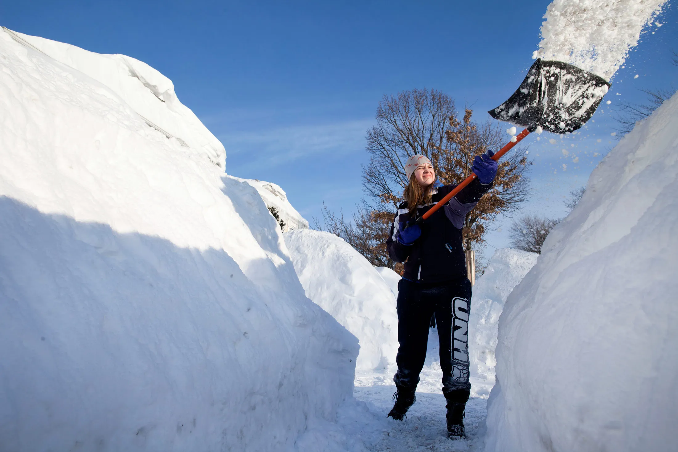 Simone Chuda works to remove snow from the sidewalk in front of her home in Cambridge,on Feb. 15, 2015.

