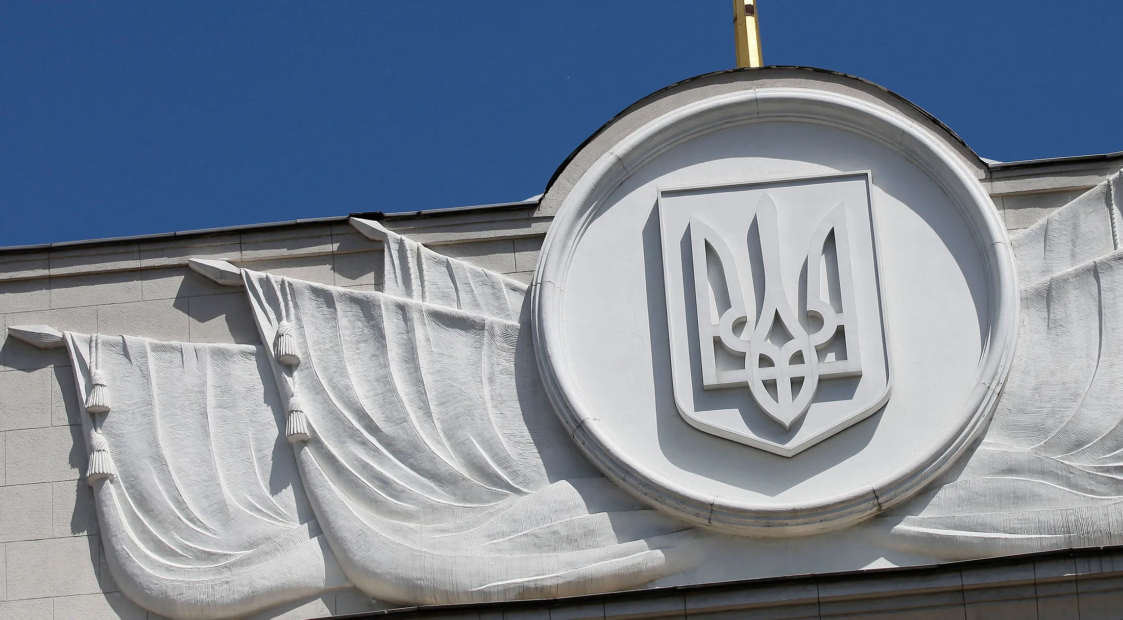 A Ukrainian national flag flies above the parliament building, or Verkhovna Rada, in Kiev, Ukraine, on Monday, May 7, 2012. Ukraine's central bank is unlikely to lower rates further after cutting its main interest rate to 7.5 percent in March, Economy Minister Petro Poroshenko said.
