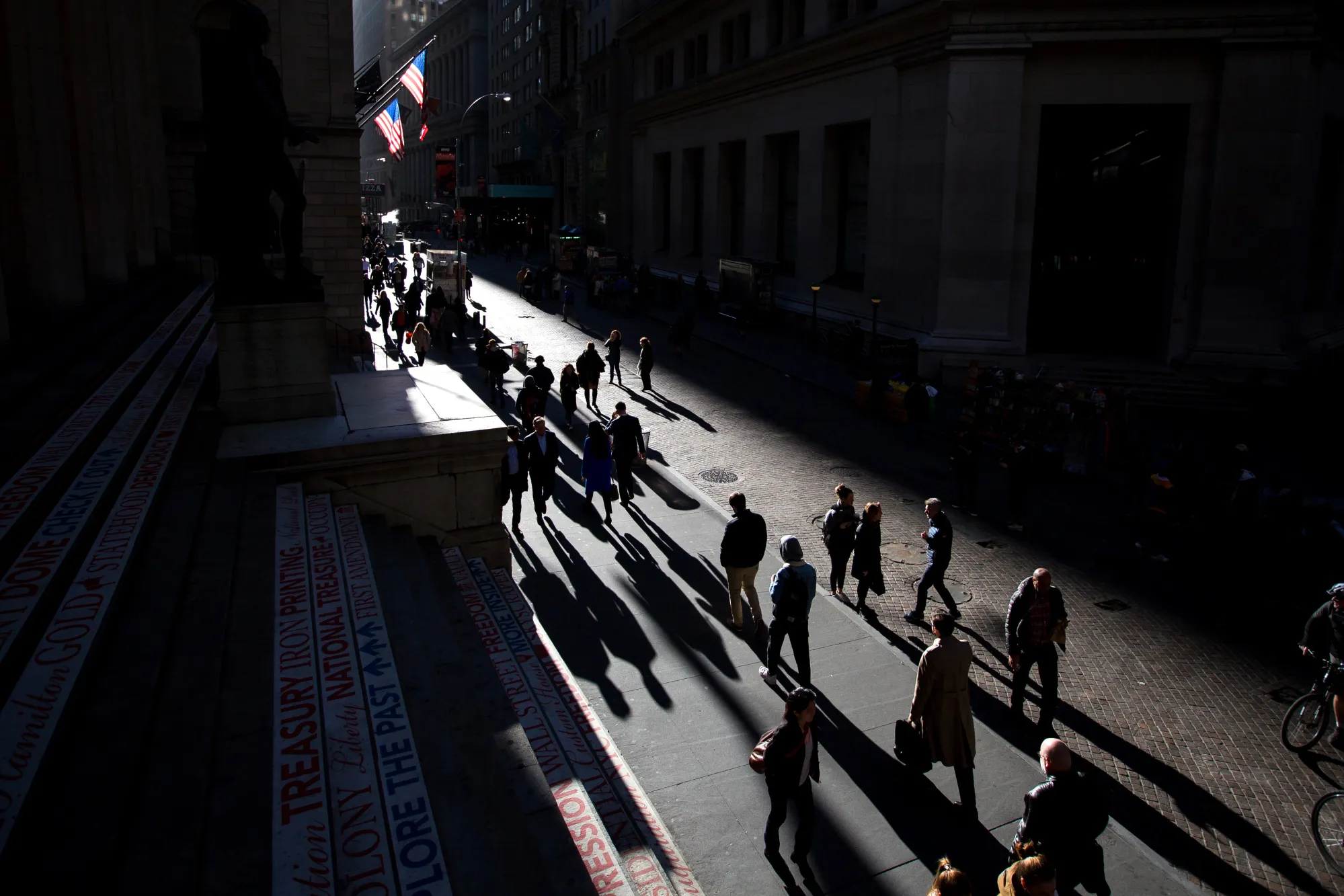 Pedestrians walk along Wall Street near the New York Stock Exchange (NYSE) in New York.