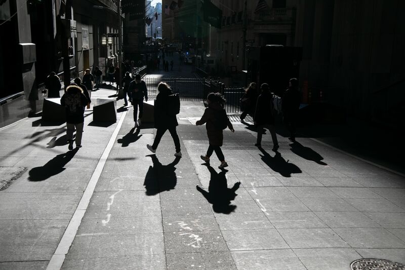 Pedestrians walk along Wall Street near the New York Stock Exchange (NYSE) in New York, US.