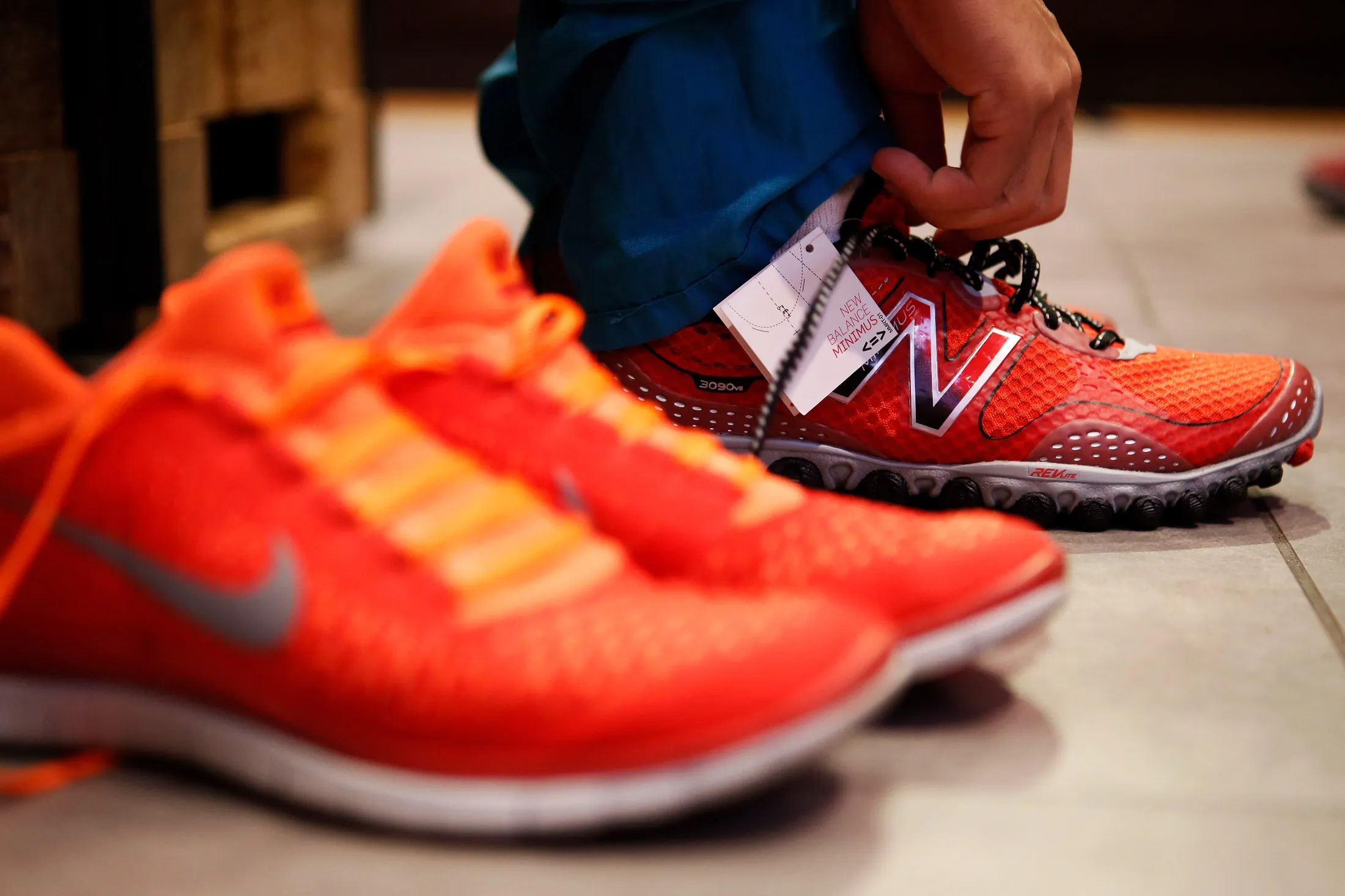 A customer tries on a New Balance sneaker at the House Of Hoops by Foot Locker retail store at the Beverly Center in Los Angeles, California, U.S., on Wednesday, Aug. 21, 2013.
