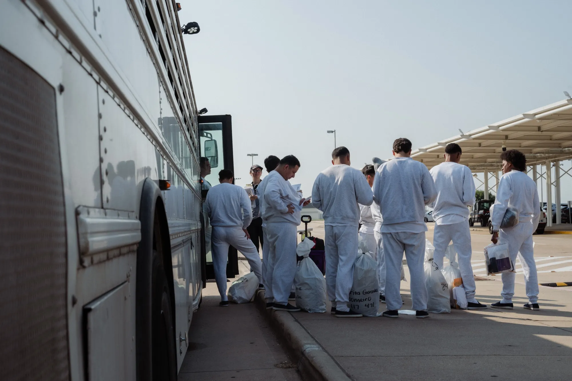 Solicitantes de asilo, liberados de detención con uniformes tipo presidiario, llegan al aeropuerto en Shreveport, Luisiana.