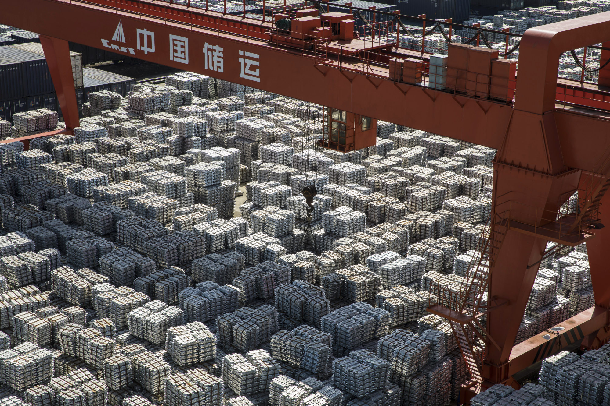 A gantry crane stands as bundles of aluminum ingots&nbsp;at a&nbsp;stockyard in Wuxi, China.&nbsp;