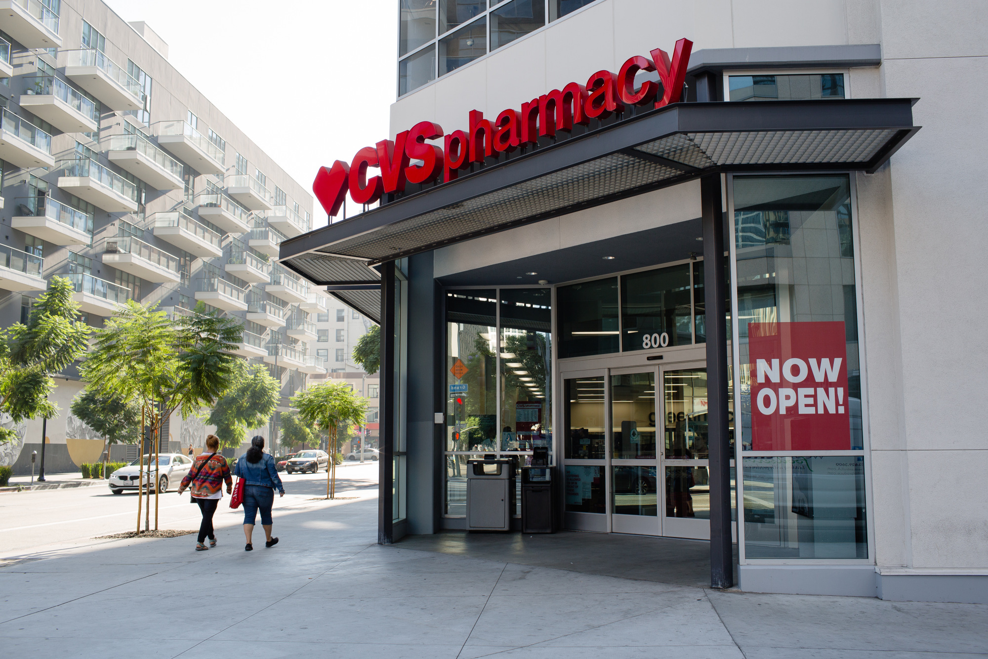 Pedestrians pass in front of a CVS Health Corp. store in downtown Los Angeles.