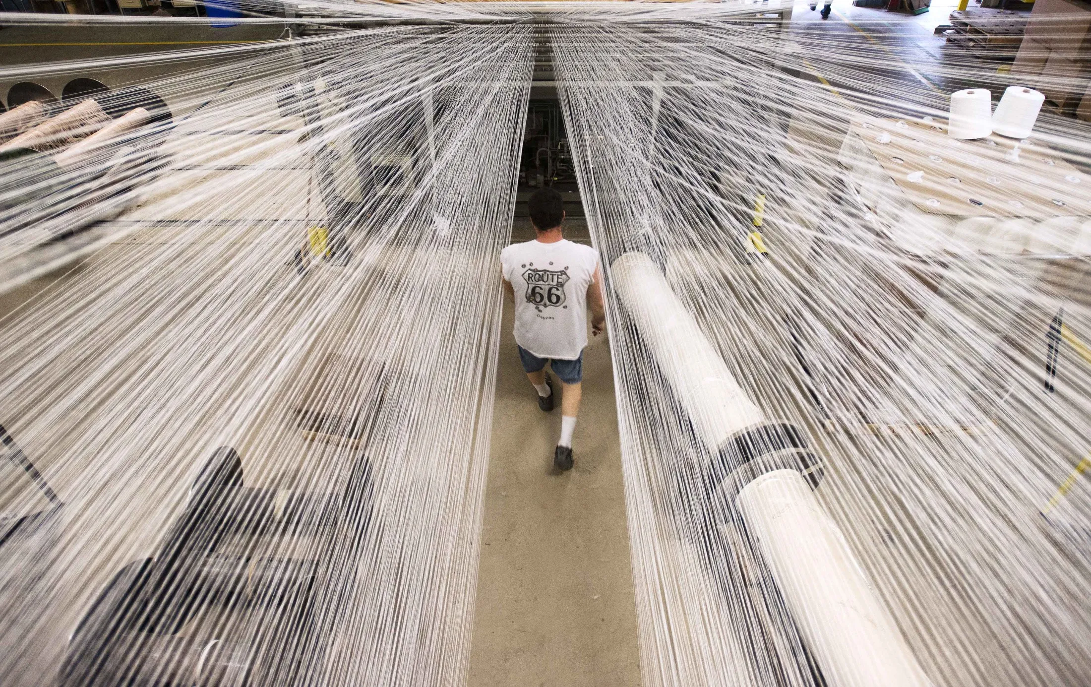 An employee loads up new rolls of material onto racks at the Bloomsburg Carpet Industries Inc. manufacturing facility in Bloomsburg, Pennsylvania, U.S.