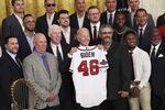 President Joe Biden poses with a jersey gifted to him by the Atlanta Braves during an event at the White House on Sept. 26. 